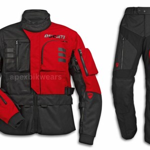 Puede incluir: Un conjunto de chaqueta y pantalón de moto Ducati negro y rojo. La chaqueta tiene múltiples bolsillos, el logotipo de Ducati y el texto "Ducati". Los pantalones tienen bolsillos con cremallera y detalles en rojo.