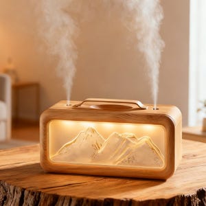 Pode incluir: Um difusor de óleos essenciais de madeira com uma cena de montanha iluminada. O dispositivo retangular tem uma alça e emite dois jatos de vapor. Está sobre uma mesa de madeira, criando um ambiente relaxante.