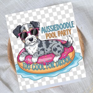 Pode incluir: Um cartão com uma ilustração de um cão Aussiedoodle usando óculos de sol rosa, flutuando em um donut rosa. O texto diz "Aussiedoodle Pool Party" e "Too Cool For Drool". O fundo tem um padrão de xadrez transparente.