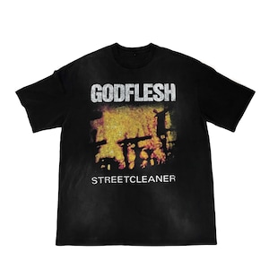 May include: Black t-shirt featuring the band name "GODFLESH" in white block letters above a blurred, yellow and red graphic. The word "STREETCLEANER" is printed below the graphic in white.