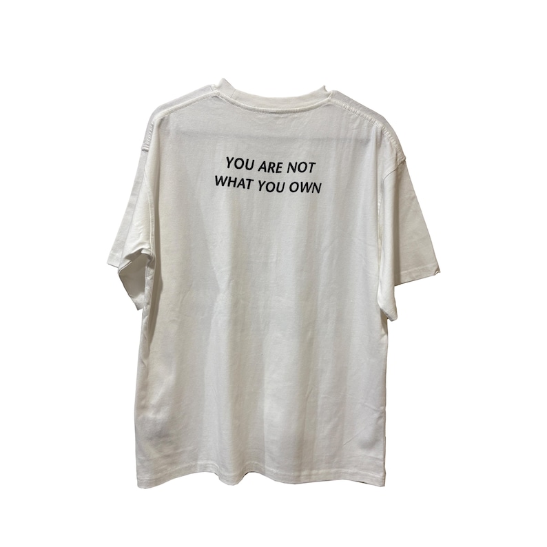 May include: White t-shirt with the text "YOU ARE NOT WHAT YOU OWN" printed in black. The shirt has short sleeves and a crew neck. The fabric appears to be a soft cotton blend.