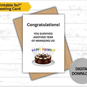 May include: A white greeting card with the text "Congratulations! You survived another year of managing us!" and a chocolate cake with candles. The card is on a brown envelope. The words "Printable 5x7" Greeting Card" are in a yellow banner.