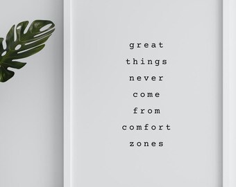 May include: A framed print with the text "great things never come from comfort zones" in a minimalist style. A white vase with green leaves is to the left of the frame. The frame is white.