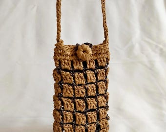 May include: A woven brown crossbody bag with a braided strap and a button closure. The bag features a grid-like pattern with dark accents. The bag is designed to hold a phone or small items.