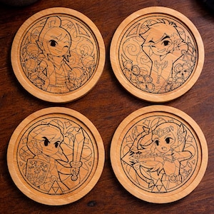 Peut inclure: Quatre dessous de verre ronds en bois avec des motifs gravés représentant des personnages d'un jeu vidéo. Chaque dessous de verre a une illustration de personnage différente, avec une bordure de style vitrail. Les dessous de verre sont sur une surface en bois foncé.