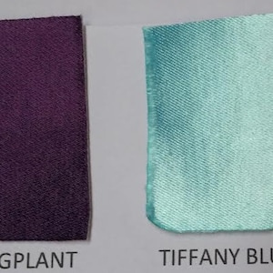 May include: Two fabric swatches, one eggplant purple and one Tiffany blue.