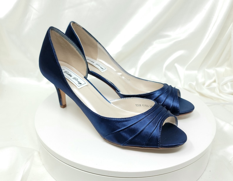 a pair of medium height navy blue satin peep toe bridal shoes