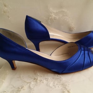 A pair of cobalt blue satin kitten heels with a peep toe