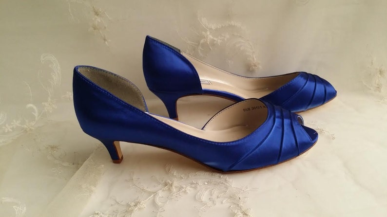 A pair of cobalt blue satin kitten heels with a peep toe