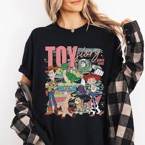 May include: A white ceramic mug with a black handle and the text "But First, Coffee" in a bold, black font. The mug is set against a blurred background, suggesting a cozy setting.