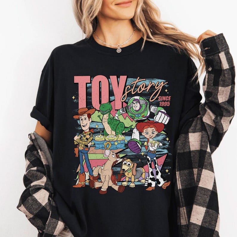 May include: A white ceramic mug with a black handle and the text "But First, Coffee" in a bold, black font. The mug is set against a blurred background, suggesting a cozy setting.