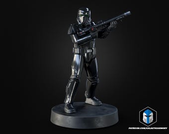 May include: A black and silver action figure of a character in a futuristic suit, holding a rifle. The figure is standing on a grey circular base. The figure has a helmet and armour. The background is black.