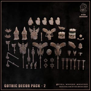 May include: A collection of miniature gothic decor items including shields, winged statues, axes, maces, swords, books, and banners. The set features detailed grey resin-style pieces arranged on a dark background with the text GOTHIC DECOR PACK - 2.