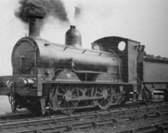 May include: A monochrome photograph of a classic steam train. The locomotive features a prominent chimney, a curved front, and several wheels. Smoke rises from the chimney, indicating it is running. The image provides a side view of the train.
