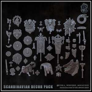 Op de afbeelding: Een verzameling grijze miniatuur spelaccessoires waaronder bijlen, schilden, banieren, wolffiguren en decoratieve emblemen. De set bevat ingewikkelde knoopwerk- en diermotieven, gelabeld als SCANDINAVIAN DECOR PACK door HYDRA WORKSHOP.