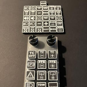 Könnte beinhalten: Schwarz-weißes 3D-SIM PRINTS Bedienfeld mit verschiedenen beschrifteten Tasten und Knöpfen. Die Tasten tragen Aufschriften wie "HUD", "ABS", "DASH" und "TC OFF". Das Panel ist für die Simulation konzipiert.