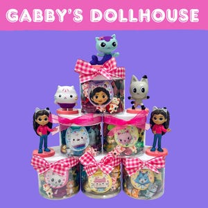 May include: Stacked jars with Gabby's Dollhouse characters and figurines. Each jar is decorated with a pink and white checkered bow and a character-themed label. The text "GABBY'S DOLLHOUSE" is displayed at the top.