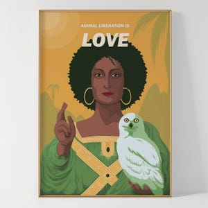 Puede incluir: Impresión artística enmarcada que presenta a una mujer con afro, pendientes de aro dorados y una túnica verde, sosteniendo un búho blanco. El texto "ANIMAL LIBERATION IS LOVE" está en la parte superior. El fondo es amarillo y verde.