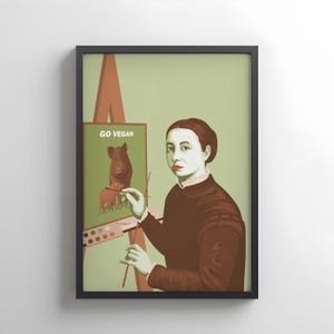 Puede incluir: Impresión artística enmarcada que muestra a una mujer con un vestido marrón pintando un cuadro de dos cerdos en un caballete. El texto "GO VEGAN" está encima de la pintura. El fondo es de color verde claro.