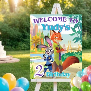 Könnte beinhalten: Willkommensschild für eine Geburtstagsfeier mit den Zeichentrickfiguren Judy Hopps und Nick Wilde aus Zootopia. Das Schild trägt die Aufschrift "Welcome to Yudy's" und "2nd Birthday" in einem farbenfrohen Design, auf einer weißen Staffelei im Freien.