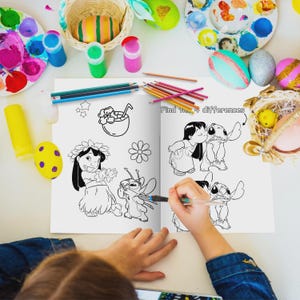 May include: A coloring book open to a page with black and white illustrations of characters. The text "Find the 4 differences" is visible. Colored pencils, paint, and decorated eggs surround the book on a white surface.