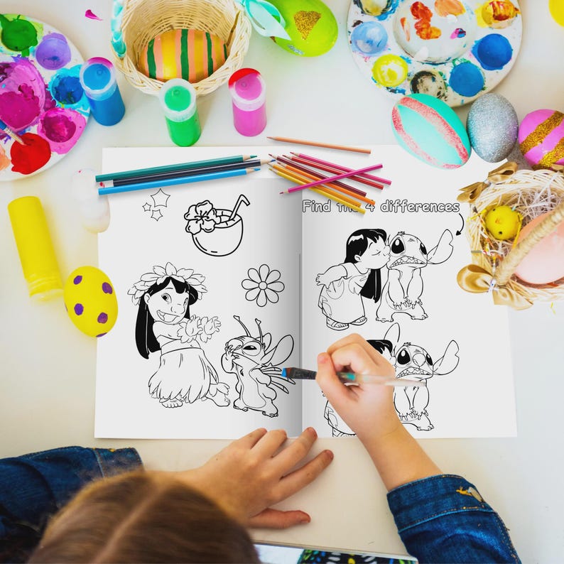May include: A coloring book open to a page with black and white illustrations of characters. The text "Find the 4 differences" is visible. Colored pencils, paint, and decorated eggs surround the book on a white surface.