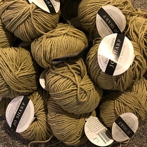 May include: A pile of beige yarn balls with white labels that read "Desert Garden Jo Sharp New Cotton".