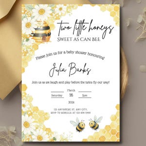Può includere: Invito per un baby shower a tema api. L'invito presenta il testo "Two little honeys, Sweet as can bee" e include il nome "Julia Banks". Il design incorpora margherite ad acquerello, favi e due api dei cartoni animati.