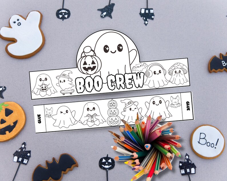 May include: A Halloween-themed craft kit featuring a "BOO CREW" headband design with ghost illustrations, a pumpkin, and other spooky characters. Includes a variety of colored pencils and Halloween-themed cookies.