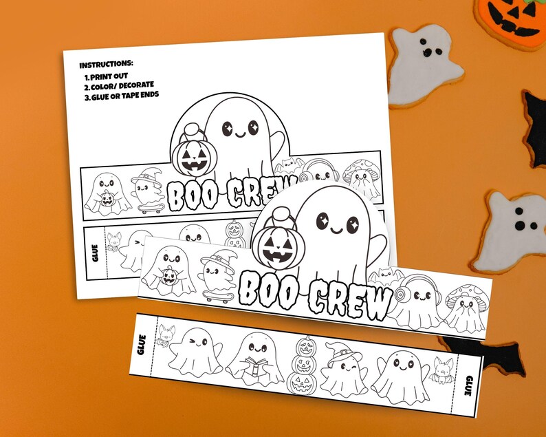 May include: Black and white Halloween-themed printable craft featuring the text "BOO CREW" and instructions. The design includes ghost characters, pumpkins, and other festive elements. The instructions are to print, color/decorate, and glue or tape the ends.