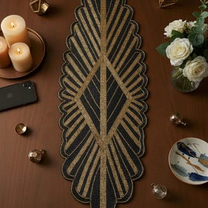 Puede incluir: Camino de mesa con cuentas negras y doradas con diseño art déco. El camino de mesa está sobre una superficie de madera marrón, rodeado de velas, rosas blancas y adornos. El camino de mesa mide unos 100 cm de largo.