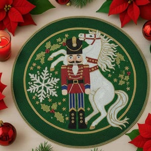 Op de afbeelding: Een ronde, groene kralen placemat met een gouden rand. Het ontwerp toont een notenkraker soldaat en een wit paard. Sneeuwvlok- en hulstaccenten zijn ook inbegrepen. Rode poinsettia's en ornamenten omringen de placemat.