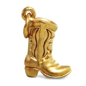 May include: A gold-colored cowboy boot charm with intricate details. The boot has a pointed toe and a decorative top.