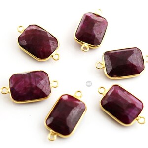 May include: Six gold-toned rectangular gemstone connectors with a deep red color. Each connector has two jump rings for attaching to jewelry.