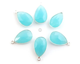 May include: Six teal blue gemstone teardrop pendants with silver bail loops.