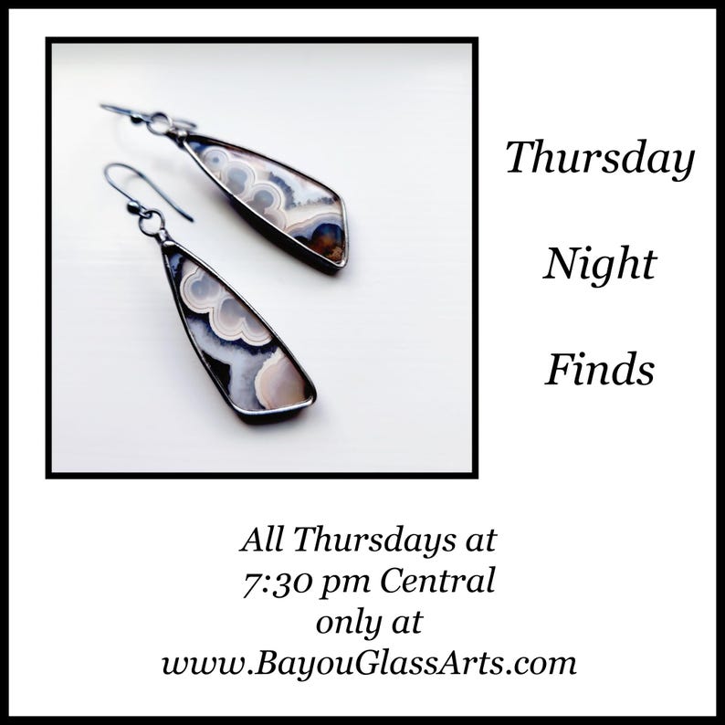 May include: A pair of teardrop-shaped earrings with a silver-colored metal frame. The earrings feature a patterned, light-colored stone with shades of white, gray, and brown. The text "Thursday Night Finds" is also visible.
