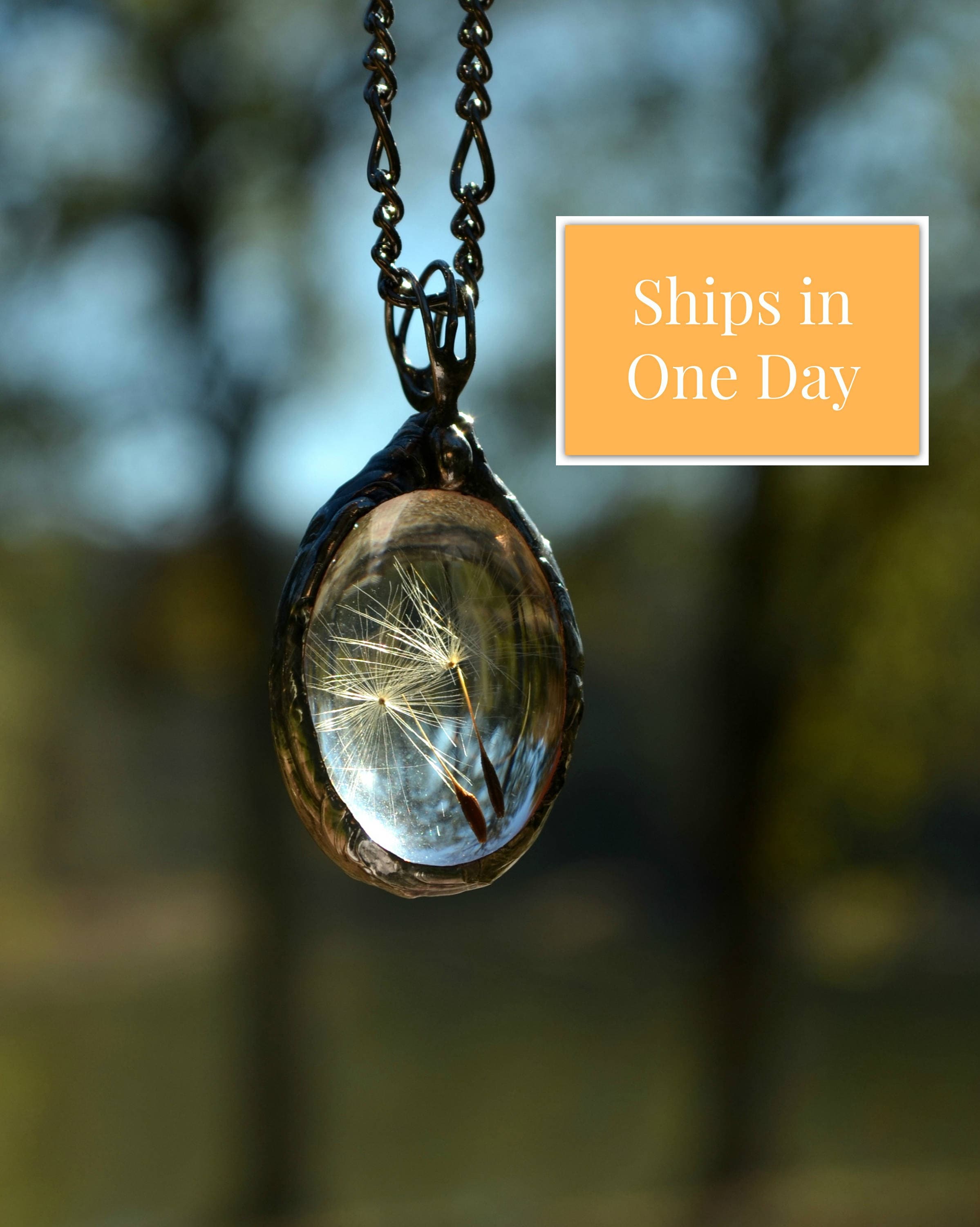 Delicate blue resin pendant with real dandelion seeds: