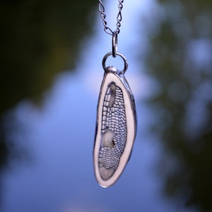 Handmade Ceramic Dragonfly Wing Pendant, in black, encased in metal. Designed by Louisiana Artisans at Bayou Glass Arts in USA.