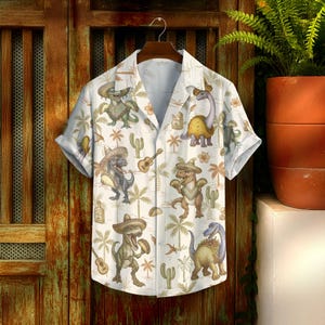 May include: Short-sleeved button-down shirt with a whimsical pattern of dinosaurs wearing sombreros, playing guitars, and surrounded by cacti and palm trees. The shirt is white with a light blue interior and a relaxed fit.