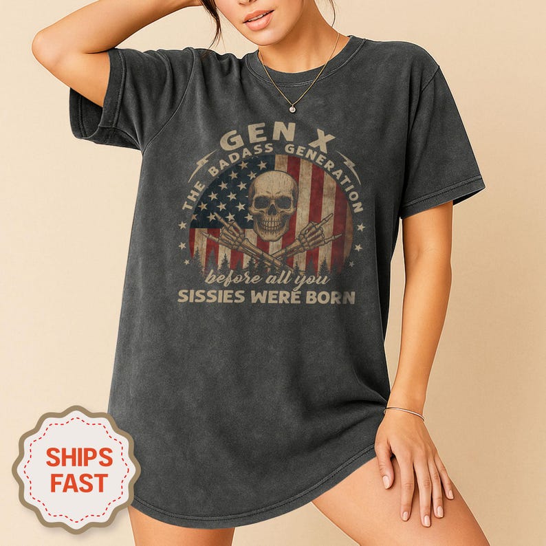 Peut inclure: Robe t-shirt gris fonc&eacute; avec un motif vieilli d'un cr&acirc;ne, du drapeau am&eacute;ricain et le texte "GEN X THE BADASS GENERATION before all you Sissies were born". Le t-shirt a un aspect vintage et us&eacute;.