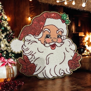 May include: A decorative Santa Claus figure with a red sequined hat and gloves, a white beard, and a gold border. Santa is giving the peace sign. A Christmas tree and fireplace are visible in the background.