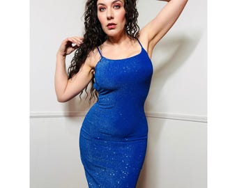 Könnte beinhalten: Eine Frau trägt ein glitzerndes blaues, ärmelloses Kleid. Das Kleid ist figurbetont und hat einen runden Ausschnitt.