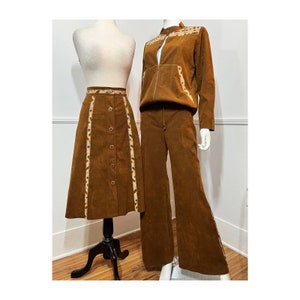 May include: A brown corduroy skirt and pants set with a geometric pattern in a lighter brown and cream color. The skirt has a button front and the pants have a drawstring waist.