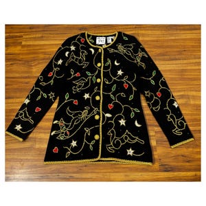 May include: Black cardigan sweater with gold, green, red, and white embroidered details. The design features a floral pattern with birds, stars, and hearts.