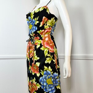 May include: A black floral print dress with a scoop neck and thin straps. The dress has a drawstring waist and a fitted silhouette.