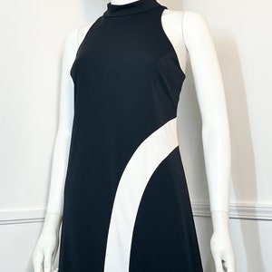 May include: A black sleeveless maxi dress with a white curved design on the side.