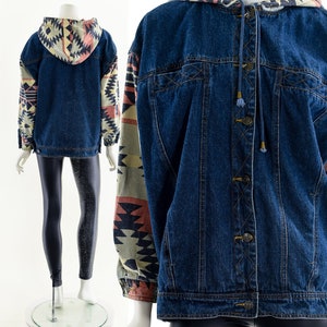 May include: A blue denim jacket with a hooded neckline and patterned sleeves. The sleeves feature a geometric pattern in shades of beige, brown, and pink.