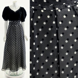 May include: A black and white polka dot maxi skirt with a sheer fabric. The skirt has a high waist and a fitted waistband.