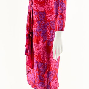 May include: A pink and red floral print dress with a gathered detail at the waist.