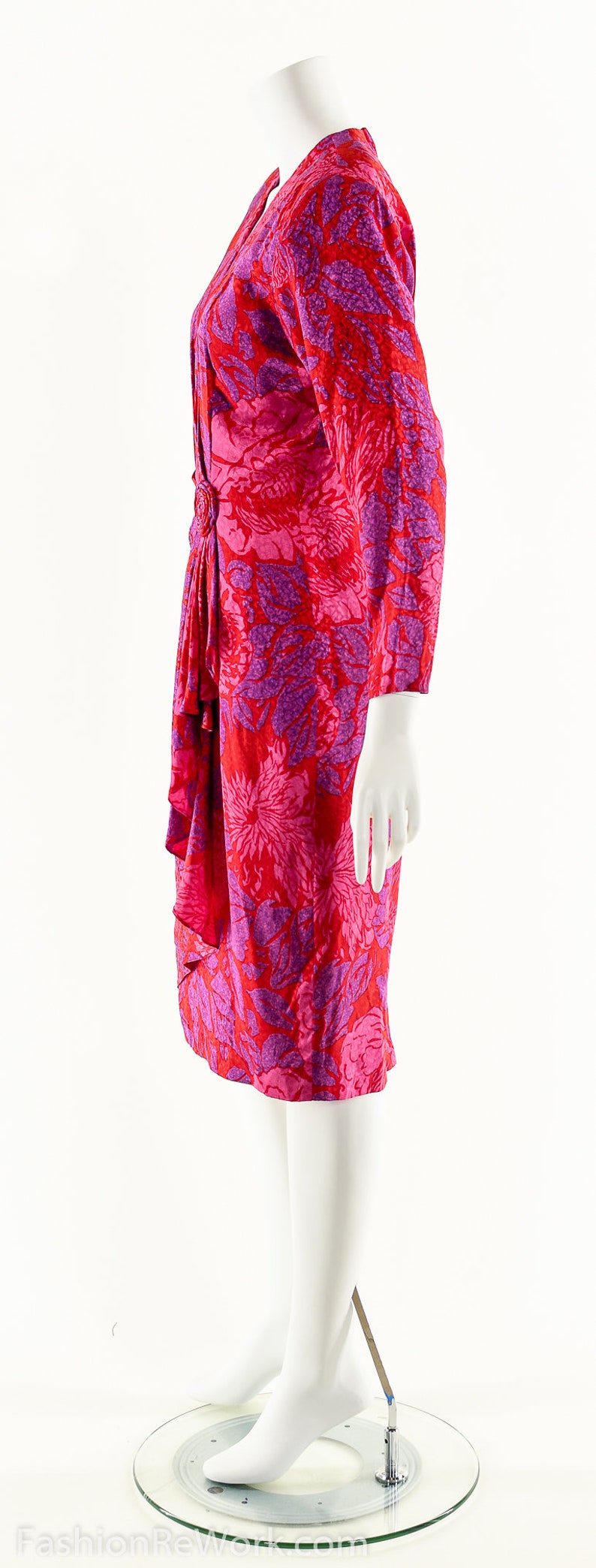 May include: A pink and red floral print dress with a gathered detail at the waist.